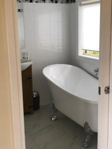 a white bath tub in a bathroom with a window at Toolebewang Farm Cottage in Launching Place