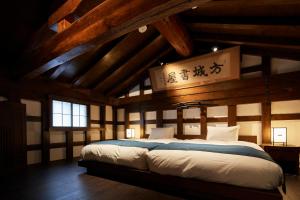 - une chambre avec un grand lit dans une pièce dotée de plafonds en bois dans l'établissement Wanoi Kakunodate, à Senboku