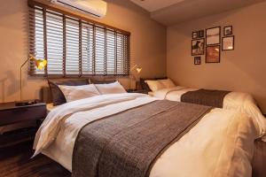 1 Schlafzimmer mit 2 Betten und einem Fenster in der Unterkunft Tino Mizuki in Osaka