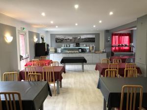 restauracja ze stołami i krzesłami oraz kuchnią w obiekcie Hôtel Restaurant le Privilège - authentic by balladins w mieście Verdun