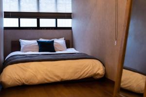 een kleine slaapkamer met een bed en een raam bij ビジュースイーツ Century in Osaka