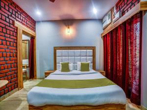 a bedroom with a large bed and a red brick wall at Sahastradhara RiverResort in Dehradun