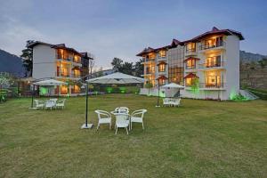 a large building with tables and chairs in front of it at Excel Hotels and Resorts Bhimtal in Bhīm Tāl