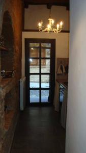 un corridoio con porta per una cucina con lampadario a braccio di Casalio a Barbarano Romano