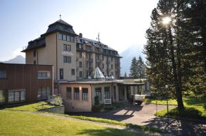 ein großes Gebäude mit einem Turm darüber in der Unterkunft Pop-up Lodge Mürren in Mürren