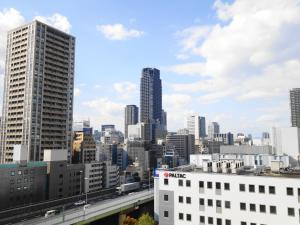 a city skyline with tall buildings and a bridge at City Plaza Osaka in Osaka