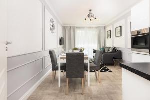 a kitchen and dining room with a table and chairs at Apartments 350m to the Beach Gdańsk Piastowska by Renters Prestige in Gdańsk