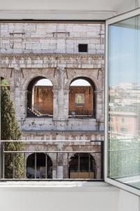 ein offenes Fenster mit Blick auf ein Backsteingebäude in der Unterkunft Amazing Colosseo in Rom