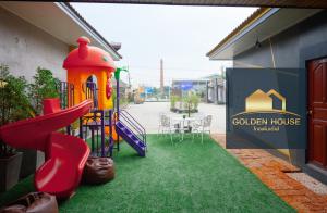 a playground with a slide in front of a house at Golden House Hotel Sakaeo in Sa Kaeo