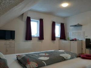 ein Schlafzimmer mit einem großen Bett mit einem Muster darauf in der Unterkunft Gästehaus B & B27 und Pension Waldhorn in Rottweil