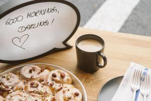 a table with a plate of donuts and a cup of coffee at The HEY HOTEL in Interlaken