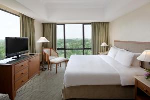 タンゲランにあるアルヤドゥータ リッポ ビレッジの大型ベッドとテレビが備わるホテルルームです。