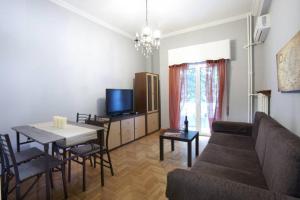 ein Wohnzimmer mit einem Sofa und einem Tisch sowie ein Esszimmer in der Unterkunft Two bedroom apartment at Koukaki in Athen