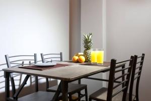 einem Holztisch mit Orangen und einem Glas Orangensaft in der Unterkunft Two bedroom apartment at Koukaki in Athen