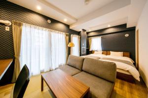 um quarto de hotel com uma cama e um sofá em VILLA KOSHIDO kotoni em Sapporo