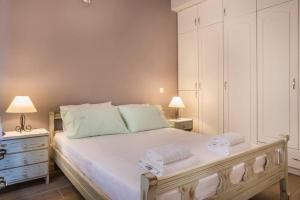 een slaapkamer met een groot wit bed met 2 lampen bij la casa di zia Anna Agia Efimia village in Ayia Evfimia