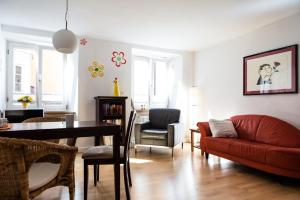 sala de estar con sofá rojo y mesa en Ferienwohnung in der Kirchgasse, en Landshut