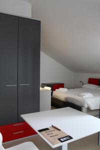 a room with two beds and a white table at SPH Hotel in Turin