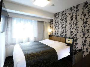 a bedroom with a bed with a black and white patterned wall at APA Hotel Ningyocho-eki Higashi in Tokyo