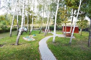 a walkway in a park with trees and a building at Bielik - Pokoje Gościnne in Płock