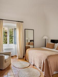 A bed or beds in a room at Mas de Torrent Hotel & Spa, Relais & Châteaux