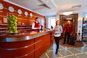 un hombre y una mujer parados en un bar en un restaurante en Hotel Moya Glinka en Samara