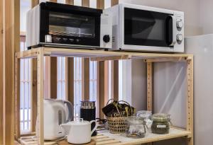 a microwave and a toaster oven on top of a shelf at Shiki Homes ZEN FUYACHO in Kyoto