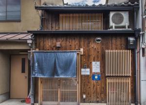 a building with a wooden door and a window at Shiki Homes ZEN FUYACHO in Kyoto