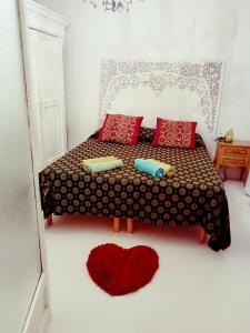 een slaapkamer met een bed met rode kussens en een hartkleed bij BIENNALE FLAT IN GIARDINI in Venetië