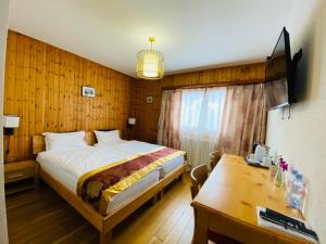 Schlafzimmer mit einem Bett, einem Schreibtisch und einem Tisch in der Unterkunft Qi-Lin Hotel Restaurant in Ayer
