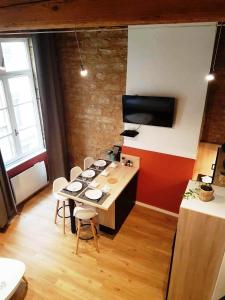 cocina con mesa y sillas en una habitación en Cosy appartement, dans les pentes de la Croix Rousse, en Lyon