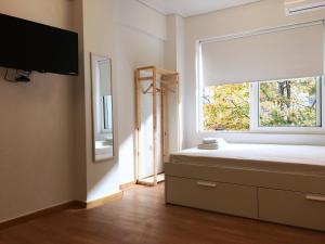 a bedroom with a bed with a window and a tv at Economy apartment B2 low budget in Larisa