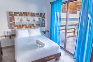 a bedroom with a bed with a view of the ocean at Hotel Blue Reef frente al mar in Mahahual