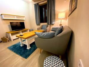 ein Wohnzimmer mit einem Sofa und einem Tisch in der Unterkunft Апартамент РАЙНОВИ in Plewen