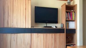 a flat screen tv sitting on top of a wooden entertainment center at Ferienhaus Ainsen in Bad Füssing