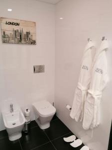 a white bathroom with a toilet and a sink at Motel Eleven in Leiria +16 photos