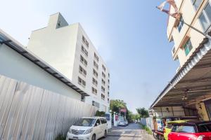 a white car parked on a street next to a building at Next Bird Suite SHA in Nonthaburi
