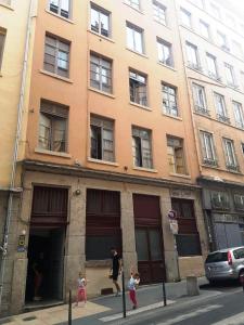 un homme et deux enfants debout à l'extérieur d'un bâtiment dans l'établissement Charmant appartement style Canut Pentes Croix Rousse, à Lyon