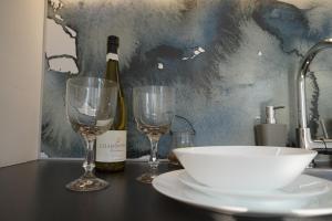 a table with two glasses and a bottle of wine at Apartament Gliwice Centrum Fredry II in Gliwice