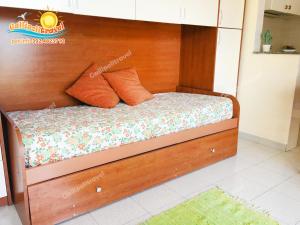 Bett mit einem Kopfteil aus Holz in einem Zimmer in der Unterkunft Bilocale Baia Verde Gallipolitravel in Gallipoli