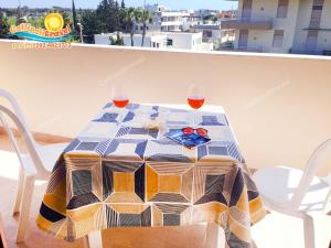 ガリポリにあるBilocale Baia Verde Gallipolitravelのバルコニーにテーブルとワイン2杯