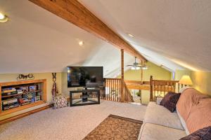 a living room with a couch and a flat screen tv at Private Family Home with Deck, Porch and Forest Views! in McComas Beach