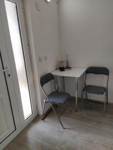 2 stoelen en een tafel in een kamer met een raam bij Ljupco Apartments in Gevgelija