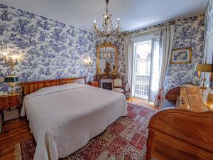 Schlafzimmer mit einem Bett und einem Spiegel in der Unterkunft Hôtel de l'Abeille in Orléans