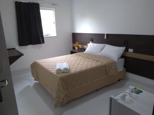 a bedroom with a bed with two towels on it at Executive Hotel in Lucas do Rio Verde