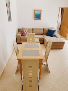 a living room with a table and chairs and a couch at Apartments Sneki in Baošići