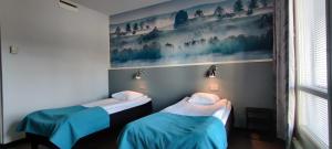 2 Betten in einem Zimmer mit Wandgemälde in der Unterkunft Tanhuvaara Sport Resort in Savonlinna