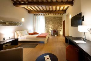 a bedroom with a bed and a living room at Mastrojanni Relais in Montalcino