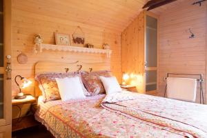 1 dormitorio con 1 cama y pared de madera en Chalet Alpinka, en Cerklje na Gorenjskem