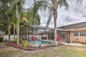 una casa con piscina y palmeras en Centrally Located Deltona Home with Pool and Yard, en Deltona